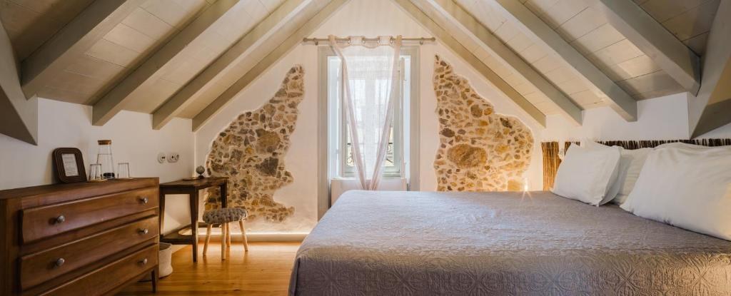 Quarto sob o telhado com vigas e paredes de pedra